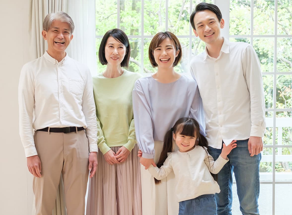 窓辺で笑顔を見せる三世代のご家族